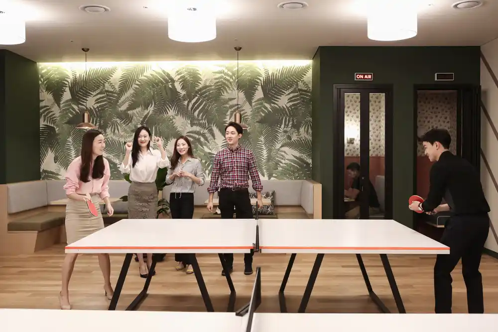 playing table tennis in the office with colleagues