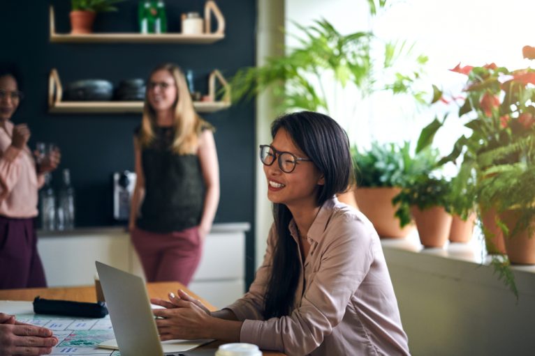 Happy Asian professional smiling during a work meeting