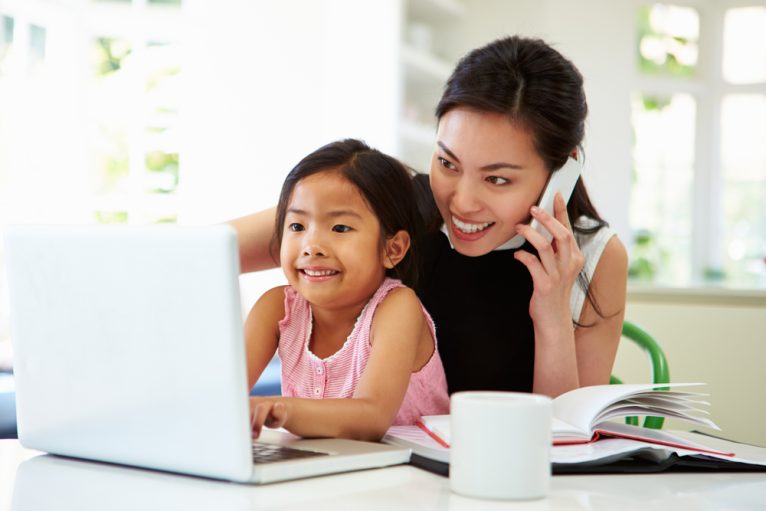 Mother with daughter playing on the laptop