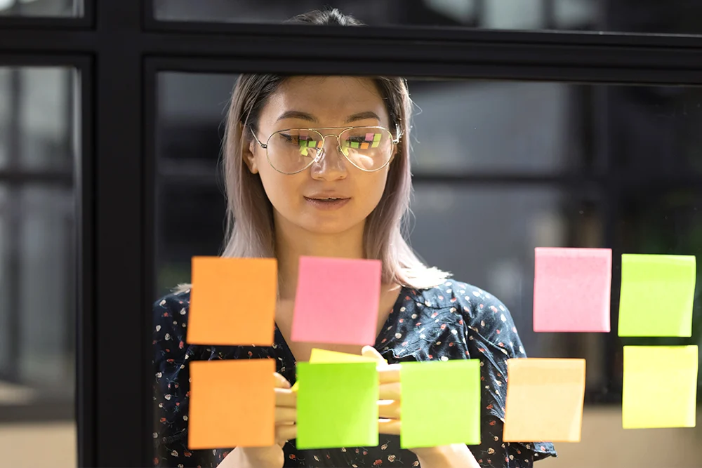 asian woman looking at post-its notes, unemployment in singapore