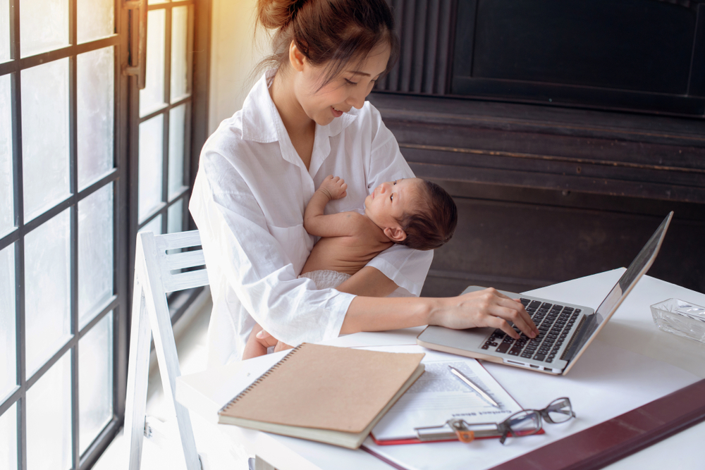 Young,Asian,Mother,Holding,Her,Newborn,Child,In,Home,Office.