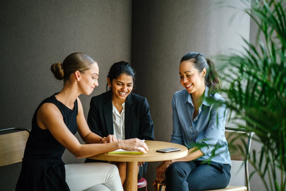 3 ladies of different races chatting in the office