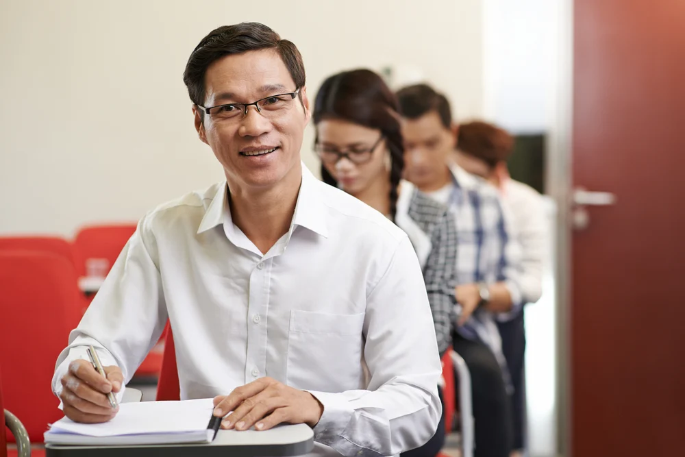 Man holding certificate over planner on desk for upskilling