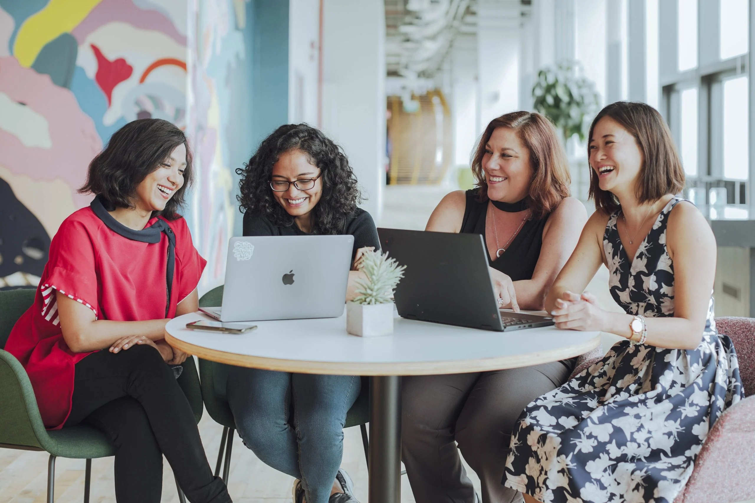 Group of four employees engaged in positive discussion