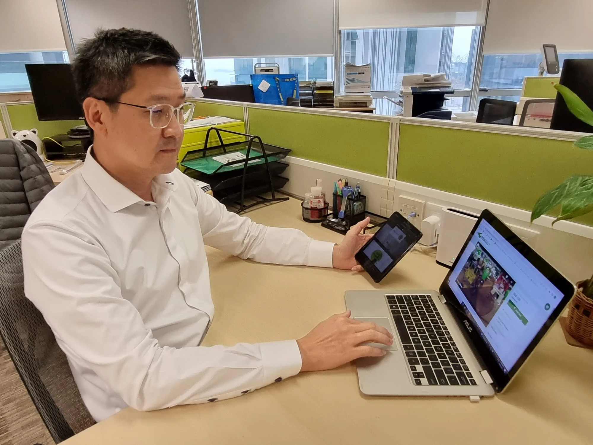 Dominic Ong in office working with a laptop