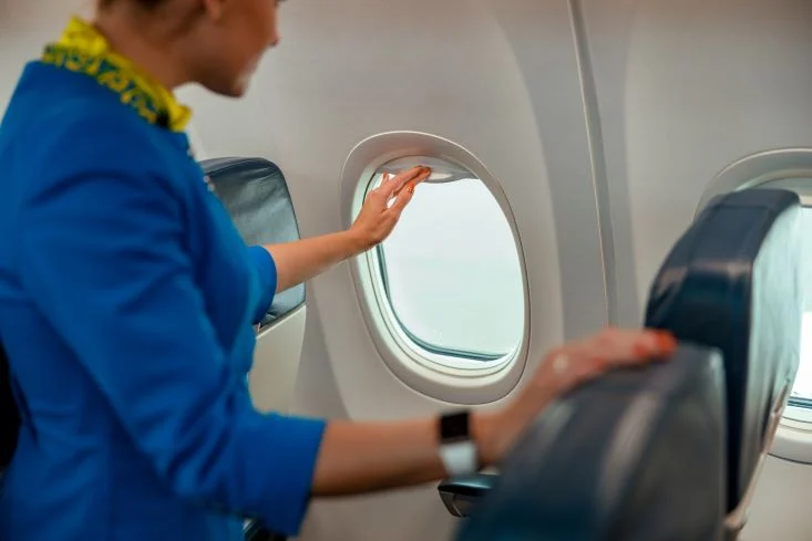 A cabin crew checking the airplane window