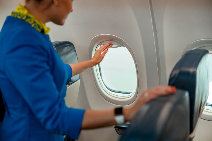 A cabin crew checking the aeroplane window