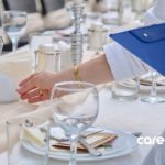 an event planner checking table settings at an event