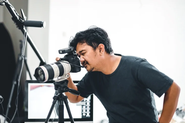 tips for aspiring content creators in Singapore, a man looking through his camera