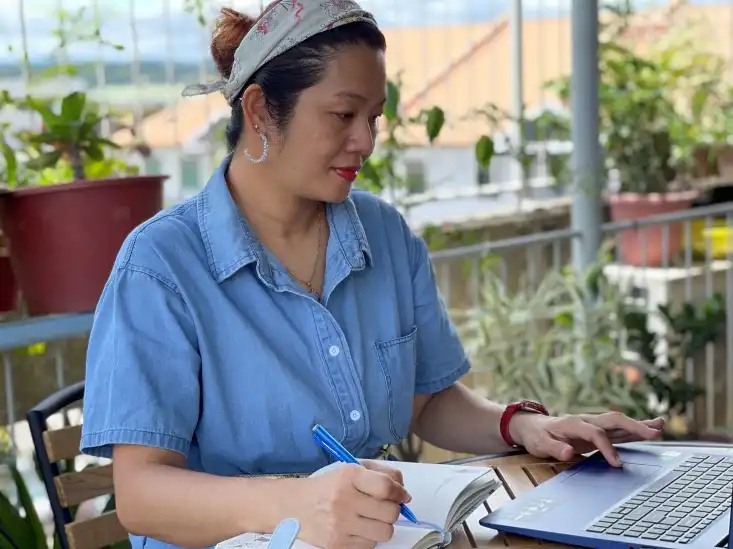 a woman learning on her laptop, sitting outdoor