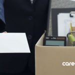 man with box of belongings handing over a resignation letter