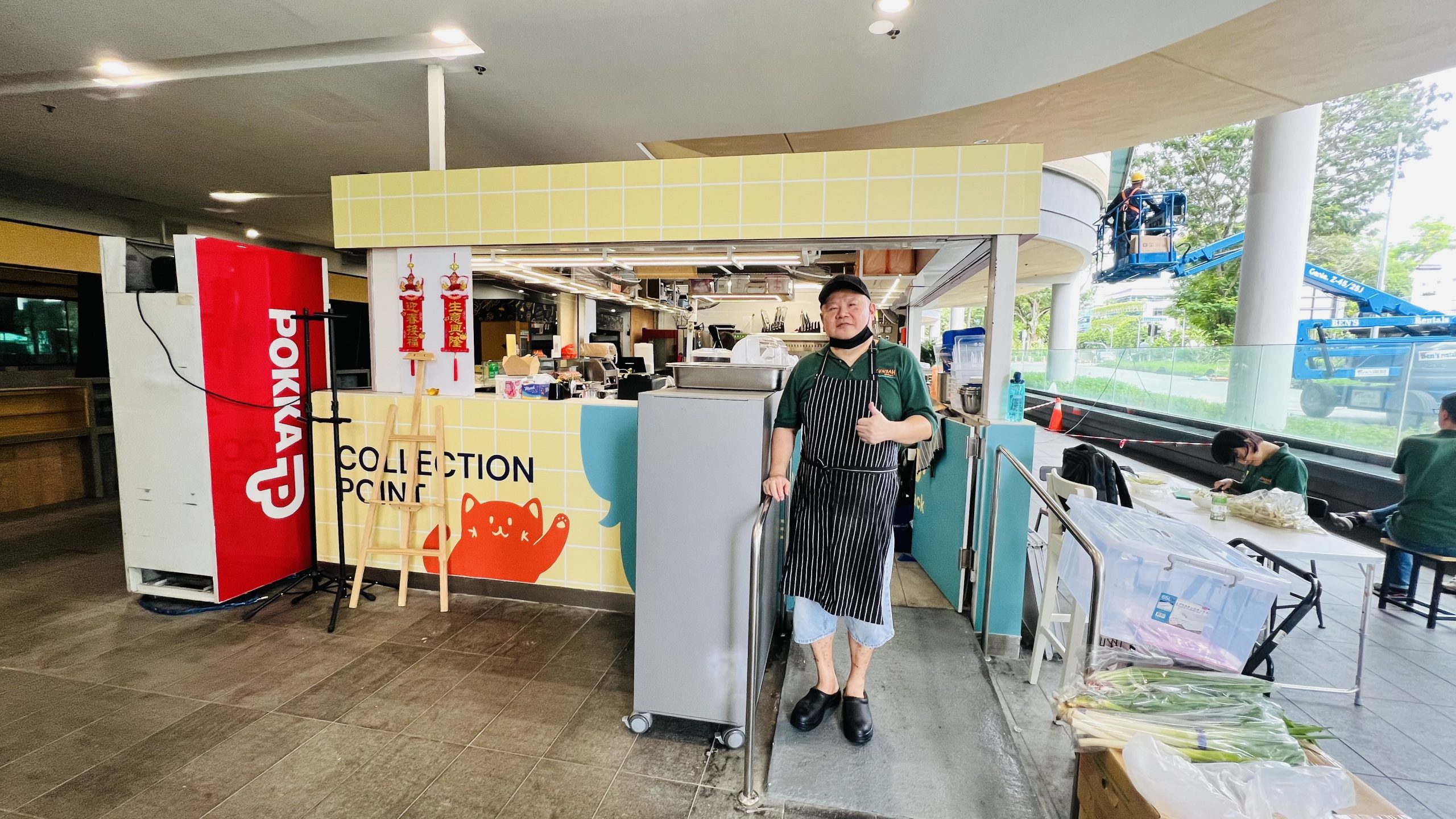 Alex as a chef in front of the shop