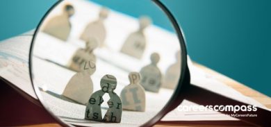 magnifying glass pointed at paper people
