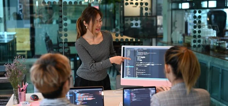 a woman pointing at the computer screen showcasing computer scripts, artificial intelligence data, future of AI artificial intelligence