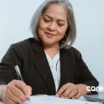 A mature woman writing on a paper