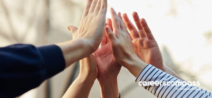 Close-up of a group of diverse hands stacked together, symbolizing teamwork and collaboration, with a soft focus background