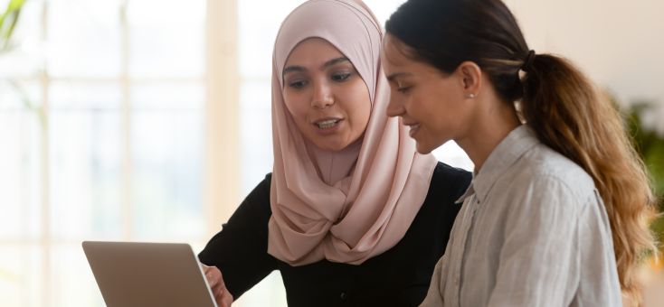 a female muslim boss guiding her subordinate