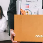 person gets retrenched holds box containing office supplies