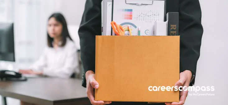 person gets retrenched holds box containing office supplies