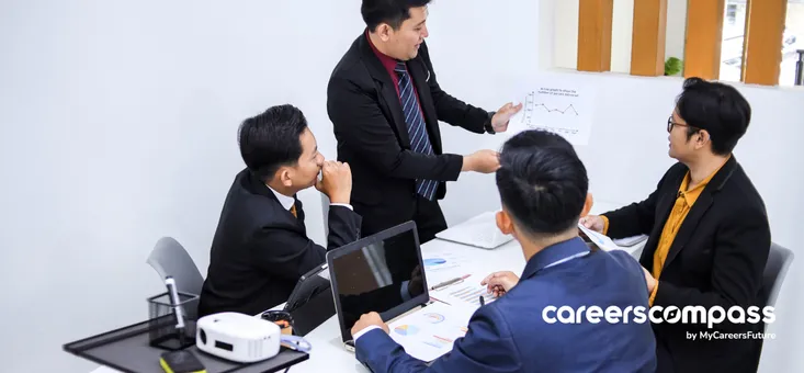 Chinese male employees wearing business suits have a work discussing in office