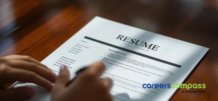 Entry-level candidate reviewing resume on table